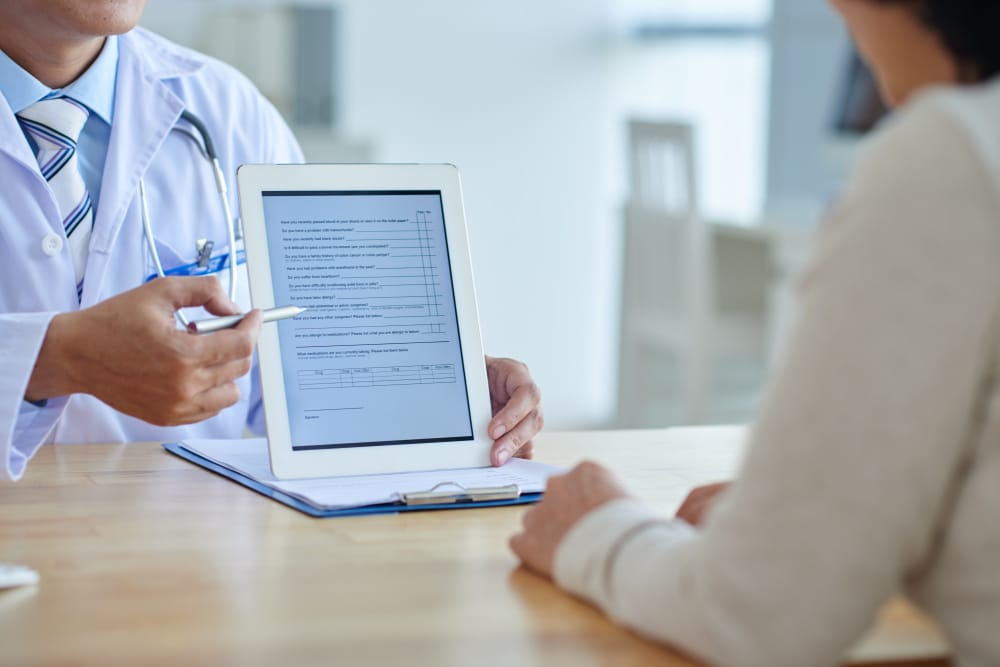 un medico mostra il fascicolo sanitario elettronico a un paziente